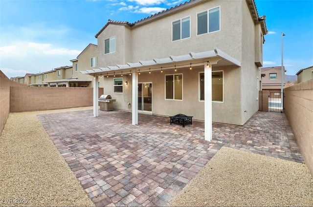 back of house with a patio area, a fenced backyard, and stucco siding