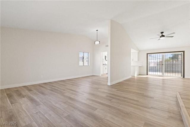 unfurnished living room featuring lofted ceiling, a healthy amount of sunlight, ceiling fan, and light wood finished floors