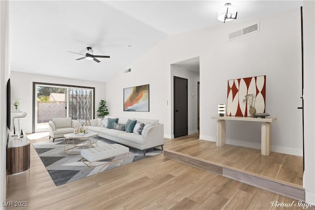 living room featuring vaulted ceiling, a ceiling fan, visible vents, and light wood-style floors