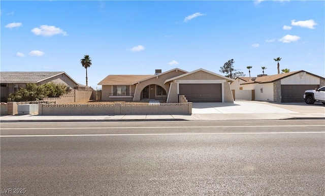 single story home featuring a garage, a fenced front yard, and concrete driveway