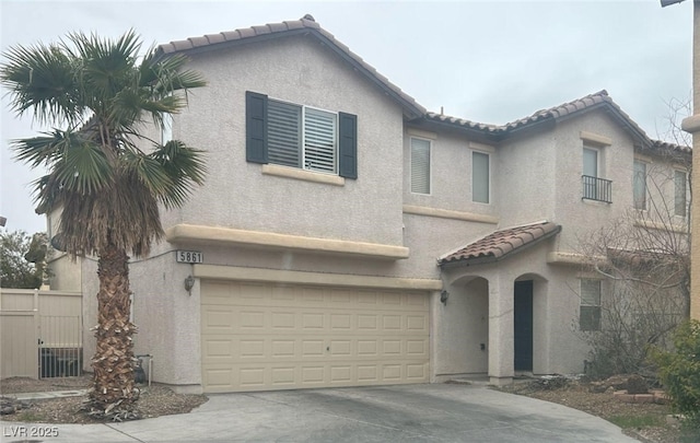 mediterranean / spanish-style house featuring stucco siding, fence, a garage, driveway, and a tiled roof