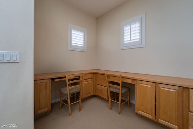 unfurnished office with built in desk and light colored carpet