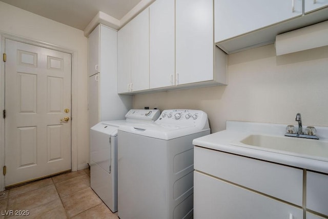 washroom with washer and clothes dryer, light tile patterned flooring, a sink, and cabinet space