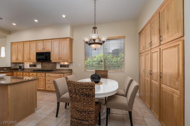 kitchen featuring plenty of natural light, gas stovetop, light brown cabinets, and black microwave