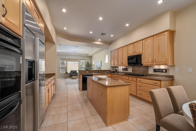 kitchen with a kitchen island, a peninsula, black appliances, a sink, and recessed lighting