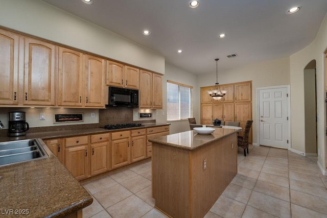 kitchen with arched walkways, a kitchen island, a sink, black appliances, and an inviting chandelier