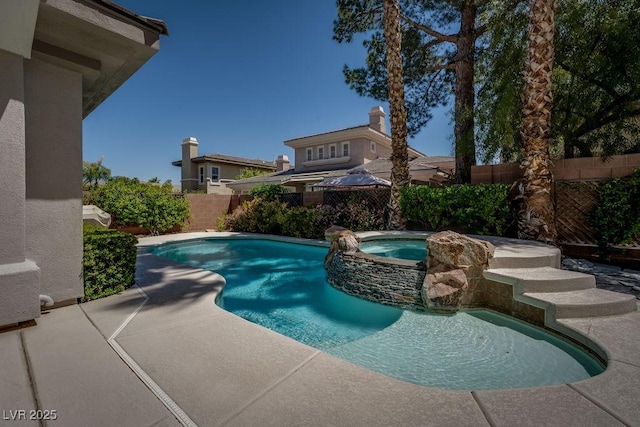 view of pool featuring a patio area, a fenced backyard, and a pool with connected hot tub