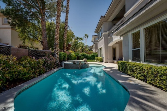 view of swimming pool with a pool with connected hot tub and fence