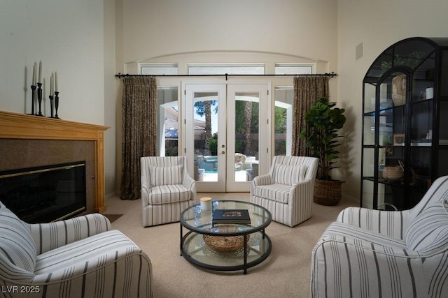 sitting room featuring carpet, french doors, a glass covered fireplace, and visible vents