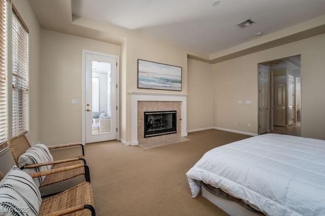 carpeted bedroom featuring visible vents, a fireplace, and baseboards