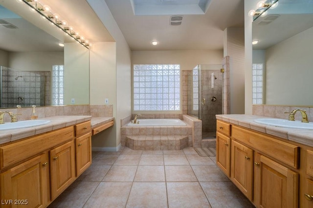 full bathroom featuring visible vents, tiled shower, a sink, and a wealth of natural light