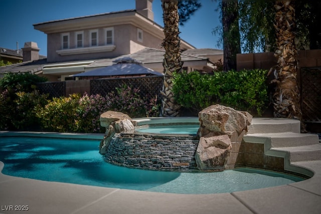 view of swimming pool featuring fence, a fenced in pool, and an in ground hot tub