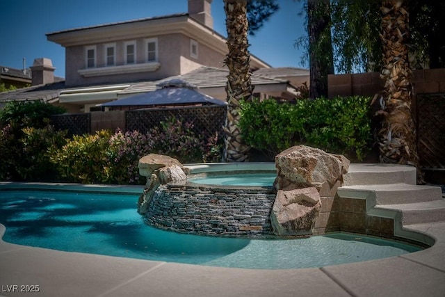 view of pool featuring a fenced in pool, fence, and an in ground hot tub