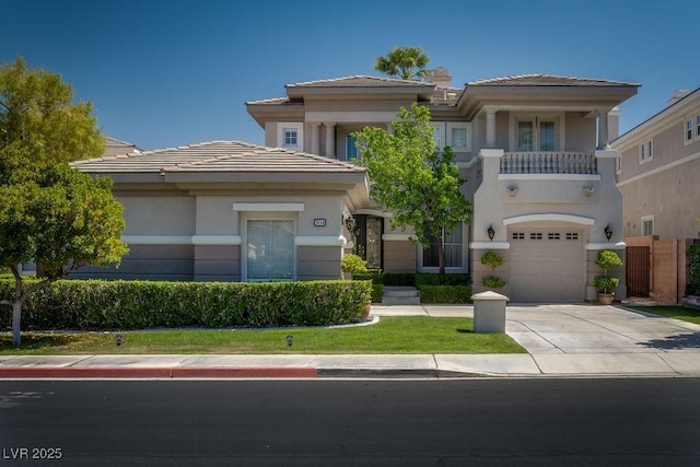 view of front of property with driveway, a balcony, a tiled roof, an attached garage, and stucco siding