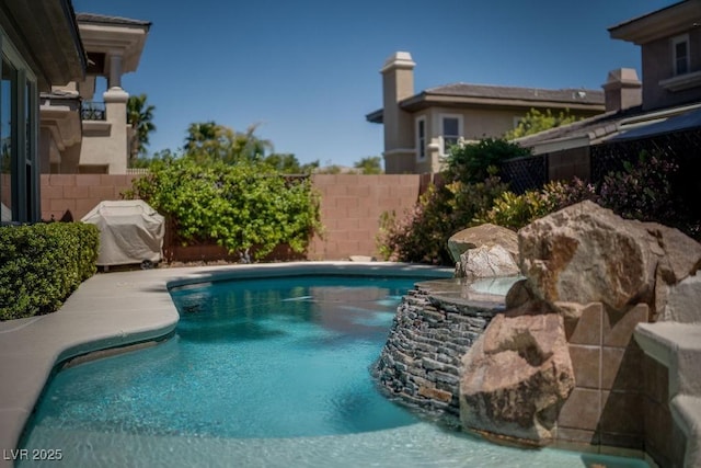 view of swimming pool featuring fence, a fenced in pool, and area for grilling