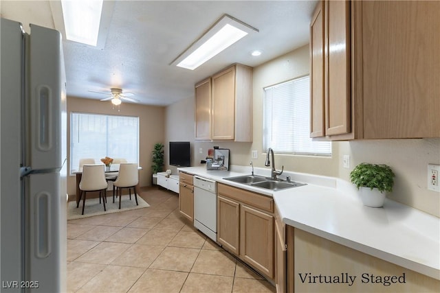 kitchen with white appliances, a ceiling fan, light countertops, a sink, and light tile patterned flooring