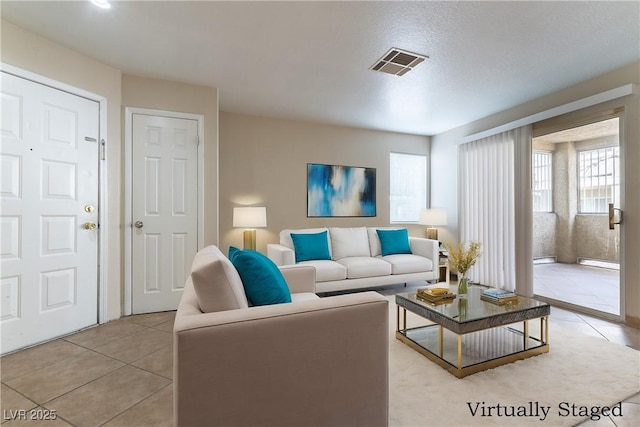 living area with light tile patterned flooring and visible vents