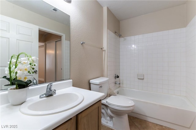 bathroom featuring a textured wall, shower / tub combination, tile patterned flooring, toilet, and vanity