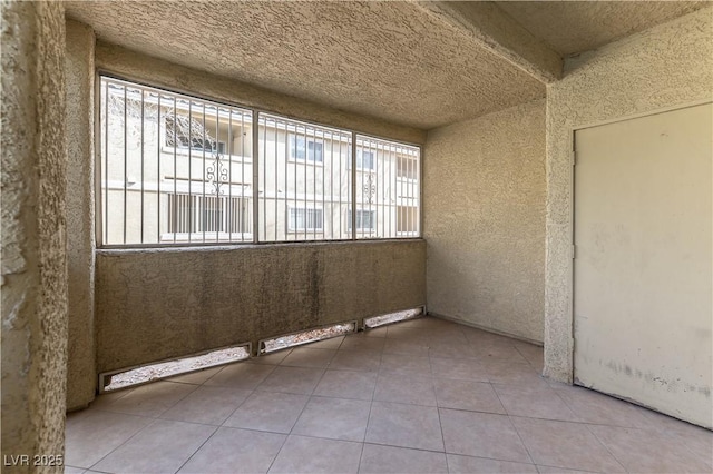 empty room featuring plenty of natural light and tile patterned flooring