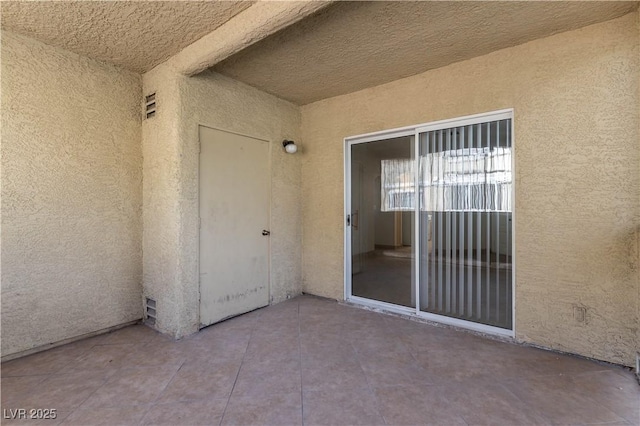 entrance to property with a patio area and stucco siding