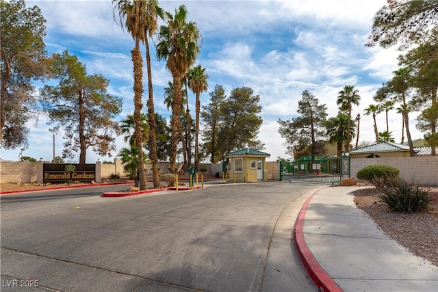 view of street with a gate, curbs, and sidewalks