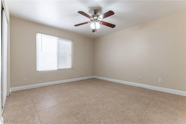 spare room with light tile patterned floors, ceiling fan, and baseboards