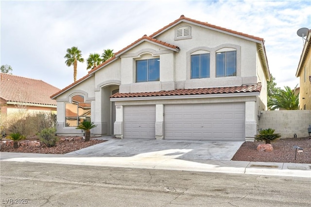 mediterranean / spanish-style home featuring an attached garage, driveway, a tile roof, and stucco siding