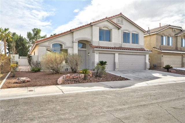 mediterranean / spanish-style home featuring stucco siding, an attached garage, fence, driveway, and a tiled roof