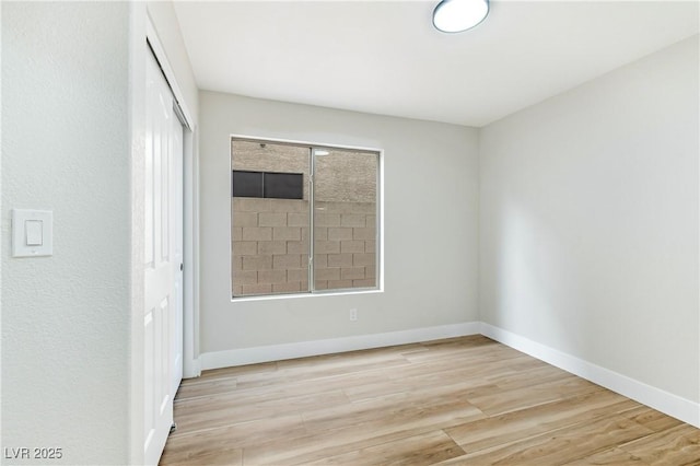 spare room featuring wood finished floors and baseboards