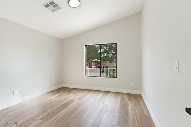 unfurnished room with lofted ceiling, baseboards, visible vents, and light wood-style floors