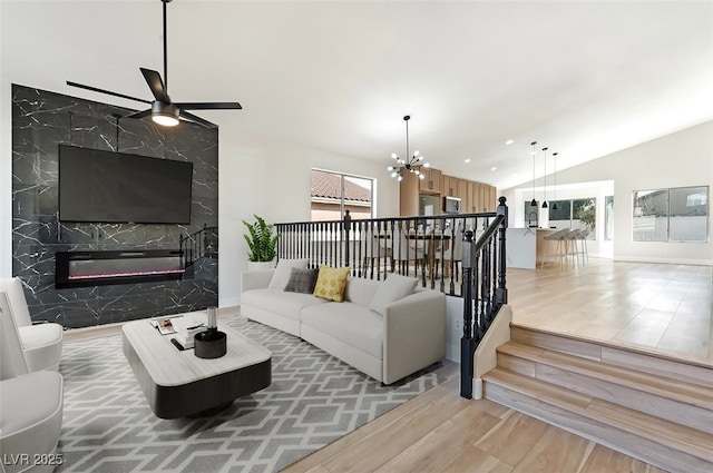 living room with lofted ceiling, stairway, plenty of natural light, and wood finished floors