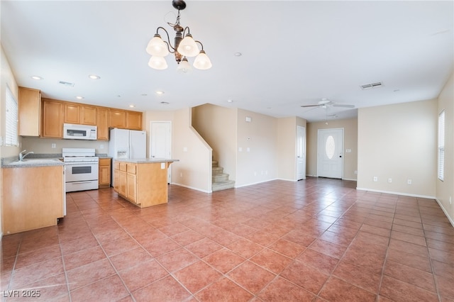 kitchen featuring open floor plan, white appliances, a kitchen island, and visible vents