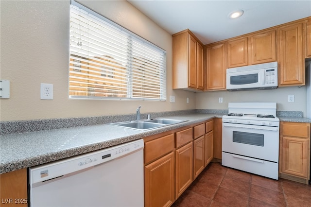 kitchen with recessed lighting, dark tile patterned flooring, white appliances, a sink, and light countertops