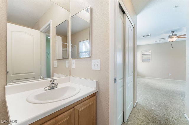 bathroom with visible vents, ceiling fan, vanity, and baseboards