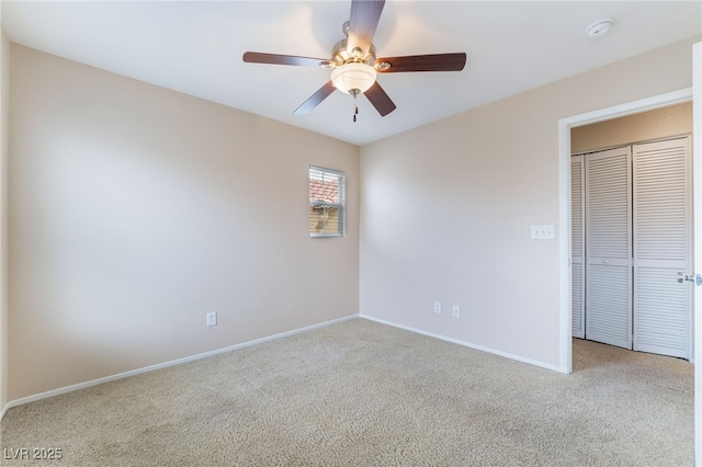 unfurnished bedroom with ceiling fan, a closet, baseboards, and carpet flooring