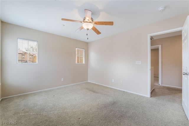 carpeted empty room with ceiling fan and baseboards