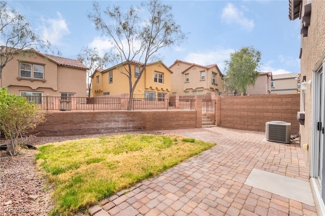 view of yard with a gate, fence private yard, a residential view, and central AC unit