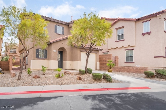 mediterranean / spanish home with a tiled roof, fence, concrete driveway, and stucco siding