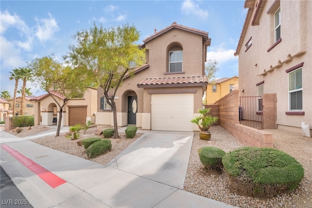 mediterranean / spanish home with a tile roof, stucco siding, an attached garage, a gate, and driveway