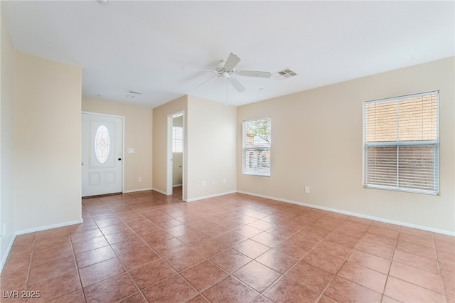 entryway with ceiling fan, tile patterned flooring, visible vents, and baseboards