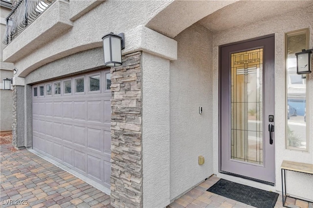 entrance to property featuring stone siding and stucco siding