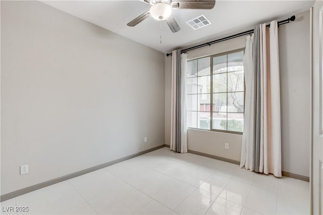 spare room with ceiling fan, visible vents, and baseboards