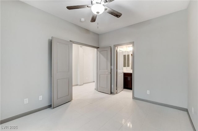 unfurnished bedroom with ceiling fan, baseboards, and ensuite bathroom