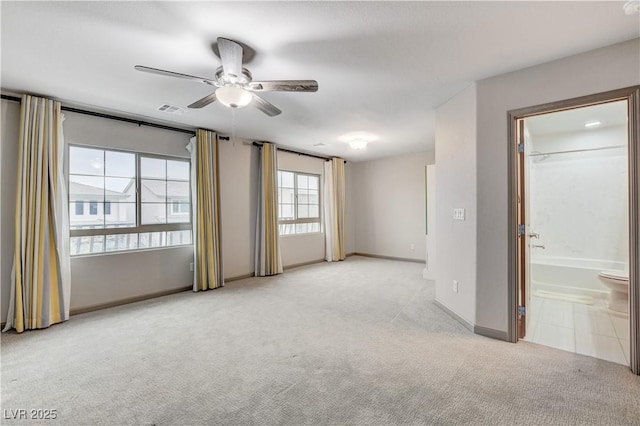 carpeted empty room with a ceiling fan, visible vents, and baseboards