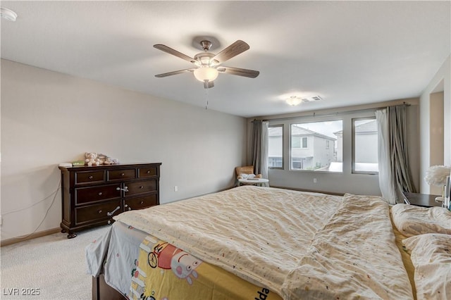 bedroom with light colored carpet, ceiling fan, visible vents, and baseboards