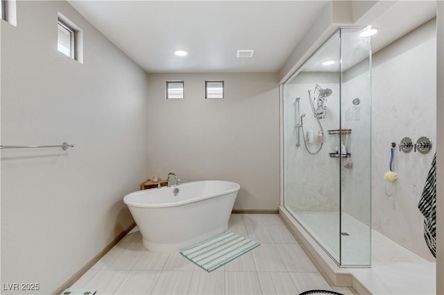 full bath featuring a freestanding tub, a healthy amount of sunlight, baseboards, and a walk in shower