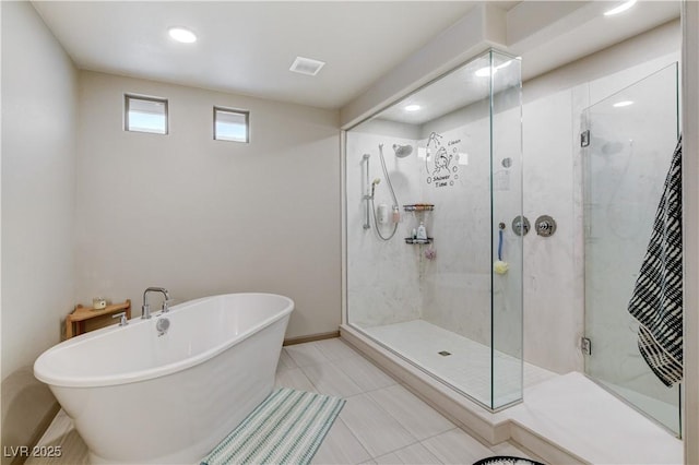 bathroom featuring tile patterned flooring, a freestanding tub, visible vents, and a shower stall