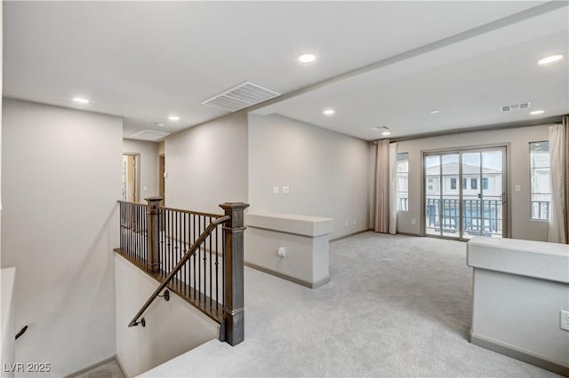 hall featuring recessed lighting, visible vents, and an upstairs landing