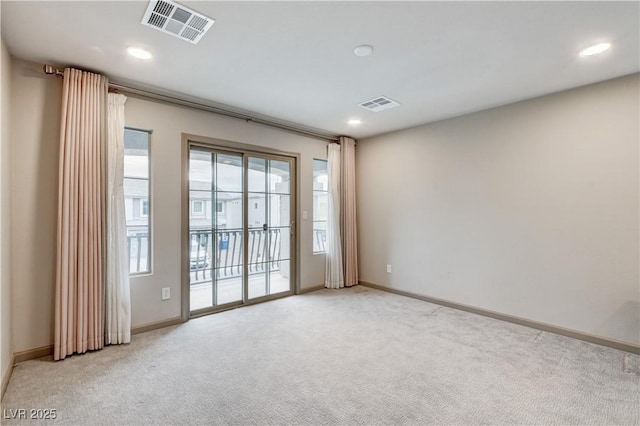 spare room with light carpet, recessed lighting, visible vents, and baseboards