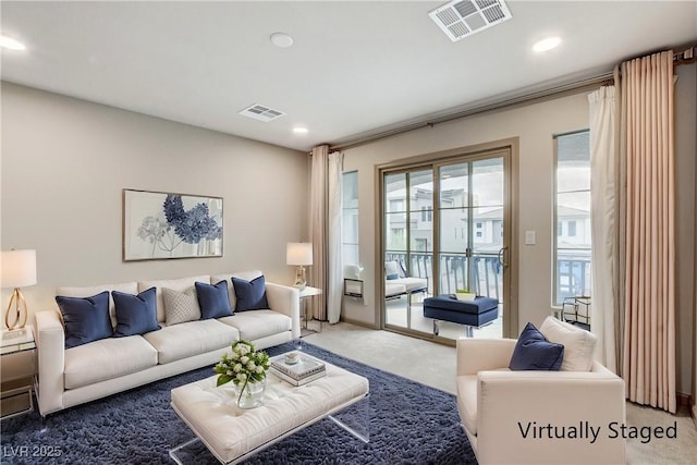 carpeted living area with recessed lighting and visible vents